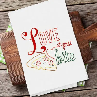 White kitchen towel with red Love at First Bite text and pizza design for Aunt Martha’s All-American Treats